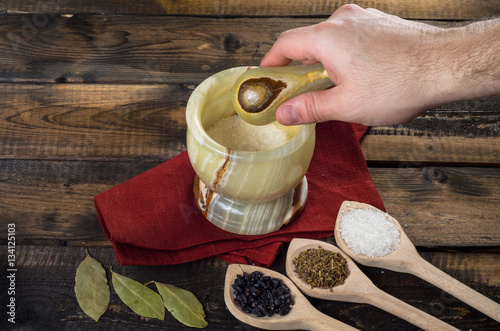 man prevents the spices in a mortar photo