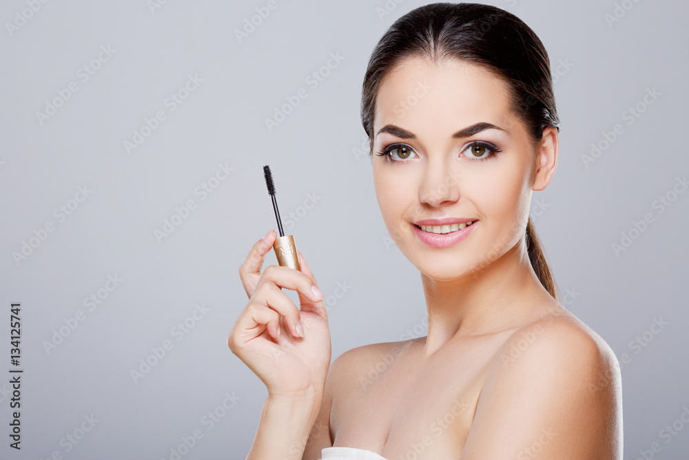Beautiful girl holding opened mascara Beautiful girl holding opened mascara