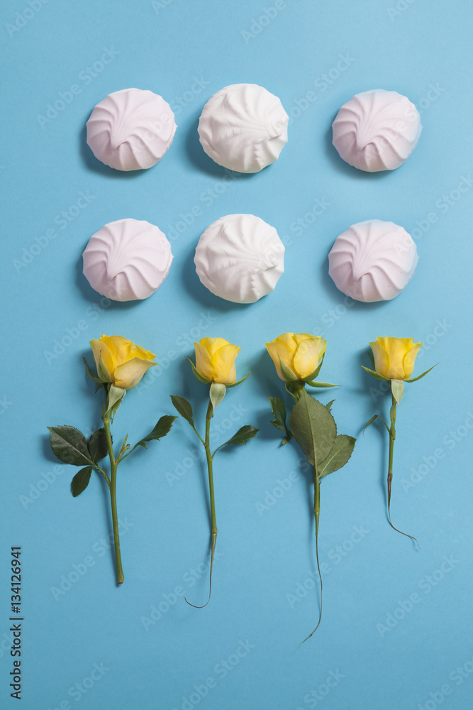 Pattern with marshmallows and yellow rose as ornament on a blue background. Fresh design for printing The summer theme.