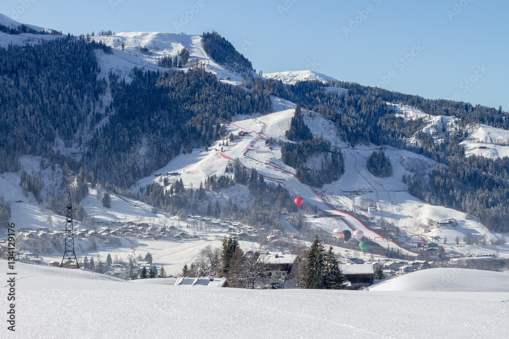 Town of Kitzbuehel in winter with Hahnenkamm and Streif on race day Foto,  Poster, Wandbilder bei EuroPosters
