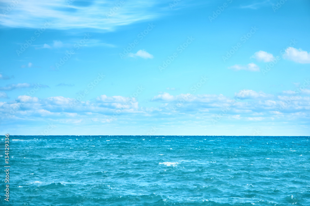 Sea water and blue sky with white clouds