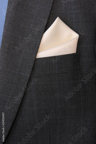 pocket square сreamy-white silk - handkerchief in the breast pocket of a man's wool luxury gray suit