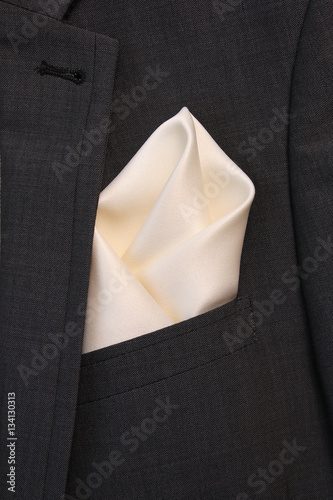 pocket square сreamy-white silk - handkerchief in the breast pocket of a man's wool luxury gray suit © oleh91