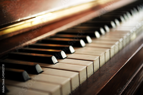 Piano keyboard of an old music instrument, close up with blurry background
