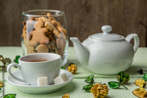 White teapot and cup with tea