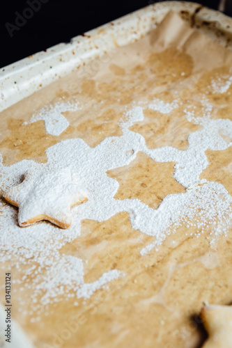 Cookie on a baking pan covered with powdered sugar.