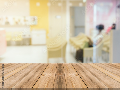 Wooden board empty table in front of blurred background. Perspective brown wood table over blur room in hospital background - can be used mock up for display or montage your products. © tirachard
