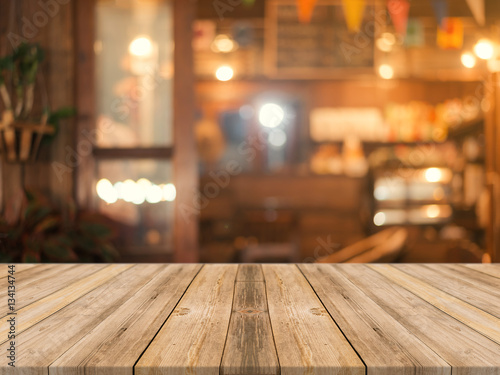 Wooden board empty table top on of blurred background. Perspective brown wood table over blur in coffee shop background - can be used mock up for montage products display or design key visual layout.