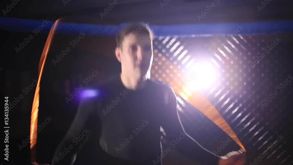 Man jumps on a skipping rope in a cage for MMA