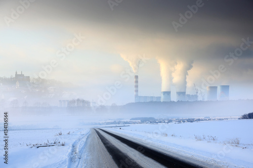Krajobraz zimowy, elektrownia węglowa z obłokami pary i dymu.
