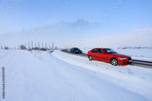 Samochody osobowe na drodze zimą.
