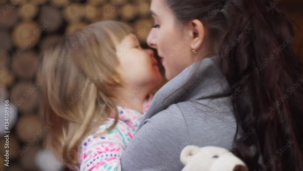 Closeup of a loving mother tenderly kissing little daughter Closeup of a loving mother tenderly kissing little daughter