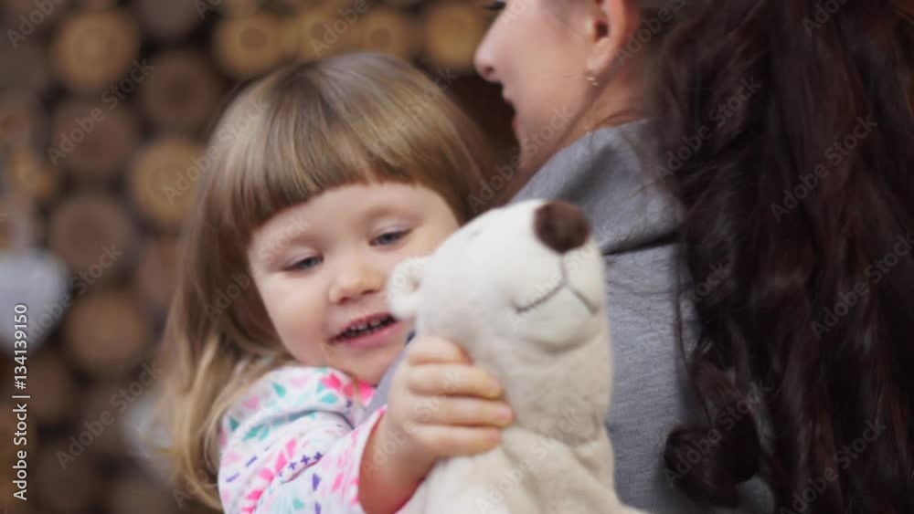 Joyful daughter with teddy bear in hand runs to hug mom Joyful daughter with teddy bear in hand runs to hug mom