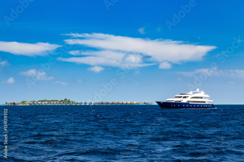 Luxury yacht in ocean near resort island with bungalows © Ivan Kurmyshov