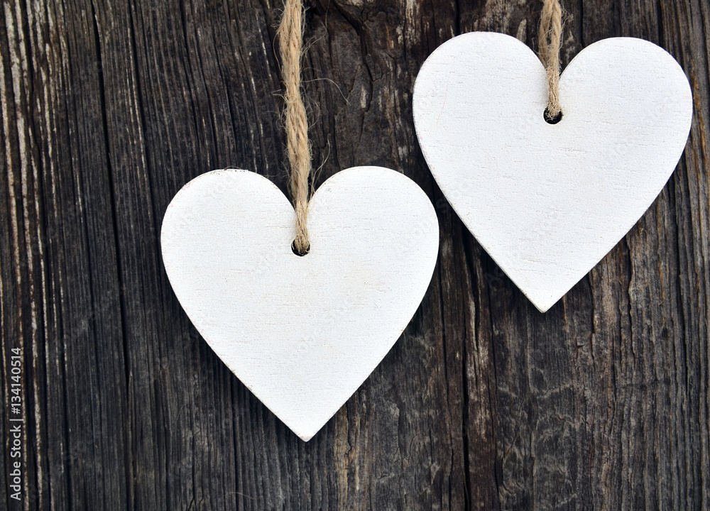 Decorative white wooden hearts on old wooden background.Two Valentine hearts.Saint Valentine's Day or Love concept.Selective focus. Decorative white wooden hearts on old wooden background.Two Valentine hearts.Saint Valentine's Day or Love concept.Selective focus.