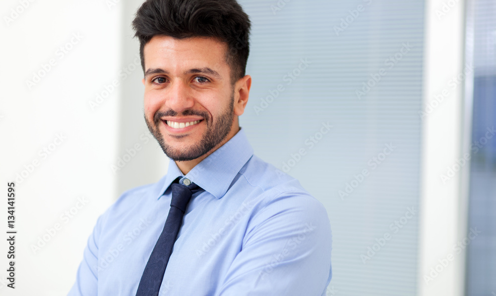 Portrait of a smiling young businessman sitting in his office Portrait of a smiling young businessman sitting in his office
