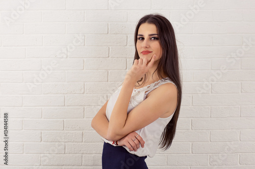 Business woman daydreaming thinking smiling white bricks wall background. Positive human emotions