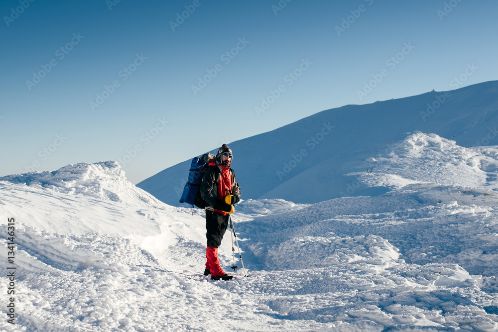 Man with backpack is hiking in snowy winter mountains Man with backpack is hiking in snowy winter mountains
