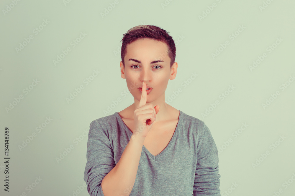 SHH. Woman wide eyed asking for silence or secrecy with finger on lips ...