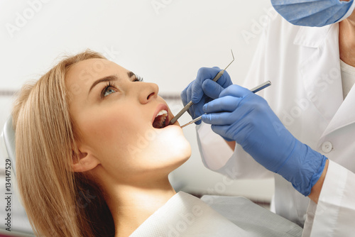 Dentist examining mouth of client