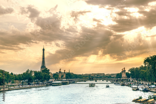 City landscape of Paris over Seine river in pastel shades. Eiffel tower and old district near opera house at dramatic sky background. Summer sunny day scenery. France.
