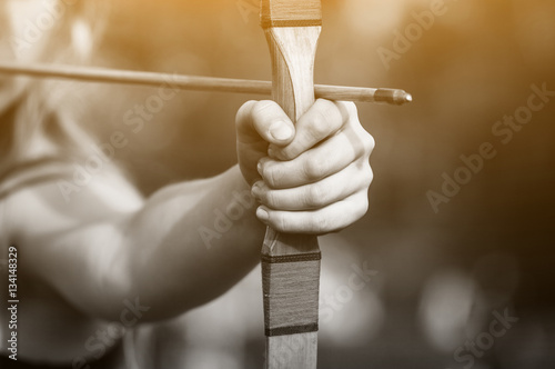 Fotografia, Obraz Athlete aiming at a target and shoots an arrow. Archery.