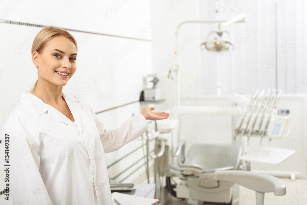 Dentist showing a chair to her client Dentist showing a chair to her client