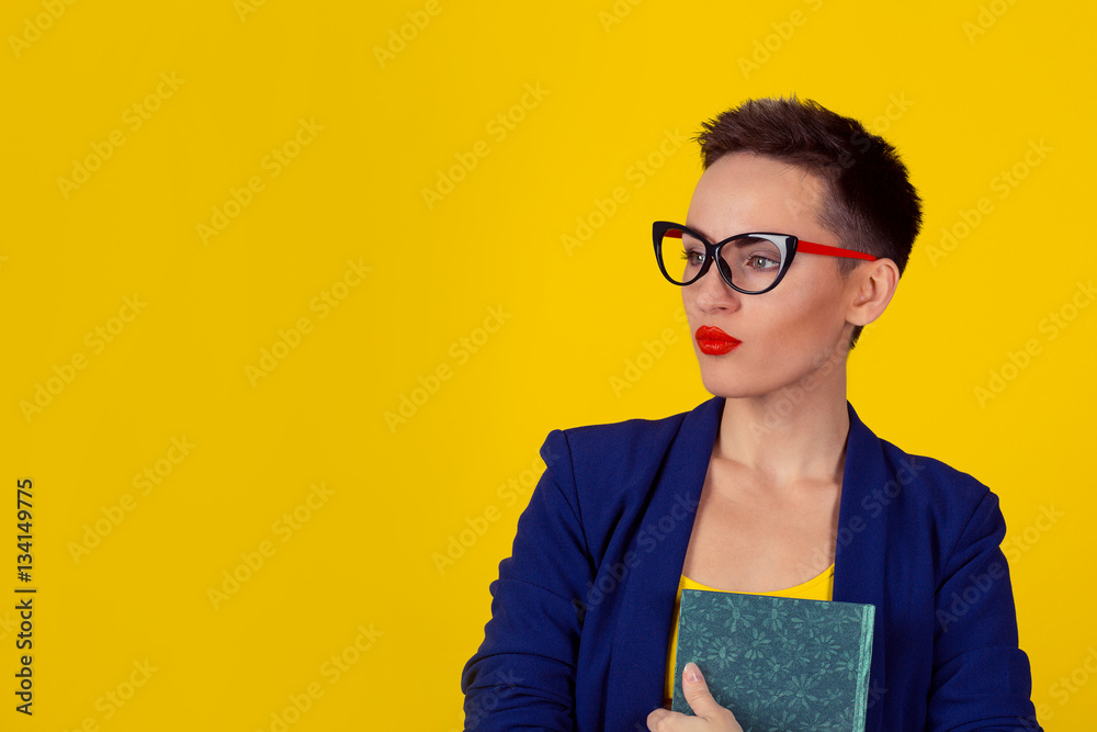beautiful business woman short hair style girl with a book isolated yellow  background copy space. Blue formal suit shirt. Daydreaming thinking head in  clouds concept. Student planning dream Stock Photo | Adobe