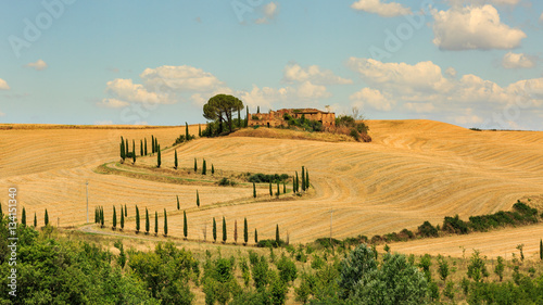 View of house with cypress trees in a field in the tuscan region photo