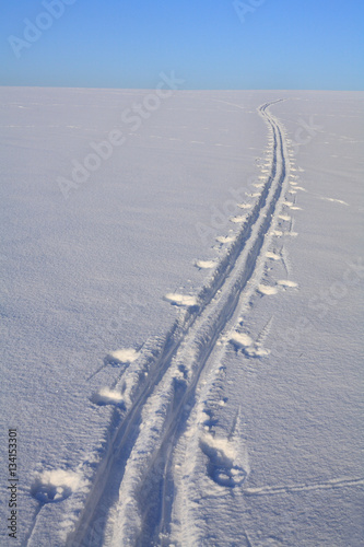 Ski trail on snowy field 