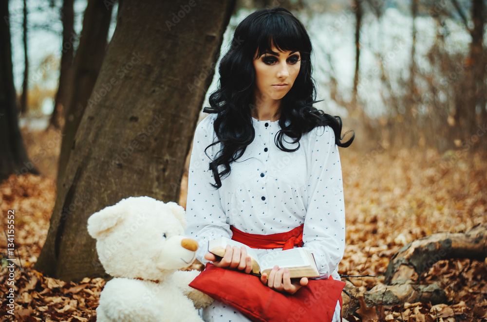 Young sad lonely brunette girl at sleepwear sitting on autumn fo Young sad lonely brunette girl at sleepwear sitting on autumn fo