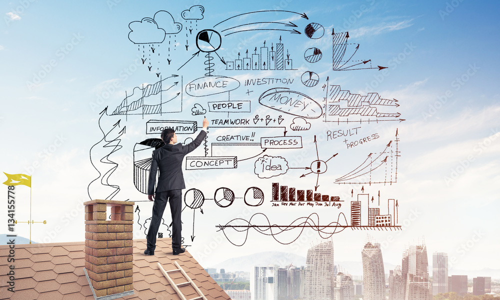 Rear view of businessman on house roof drawing his new business Rear view of businessman on house roof drawing his new business