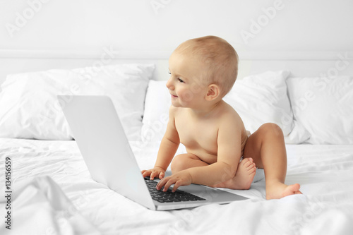 Cute baby boy with laptop o...