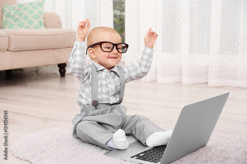 Cute baby boy with laptop o...