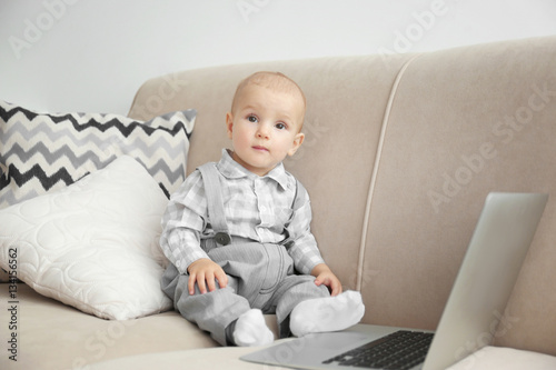 Cute baby boy with laptop o...