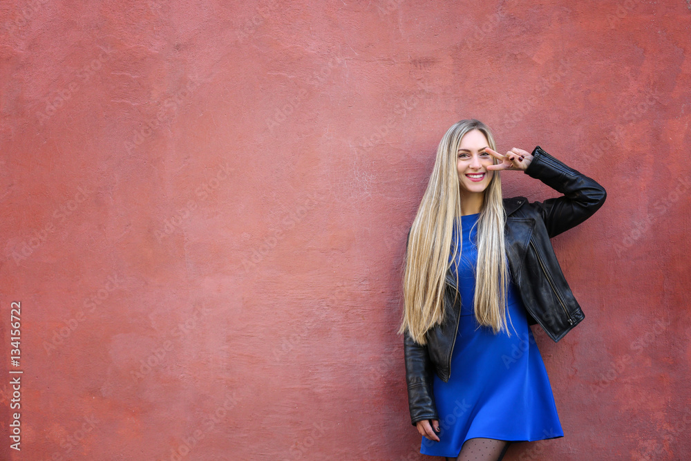 Beautiful young woman outdoors near grunge wall