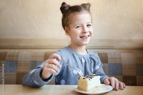 Cute little girl eating tas...