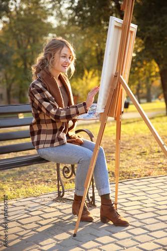 Young female artist paintin...