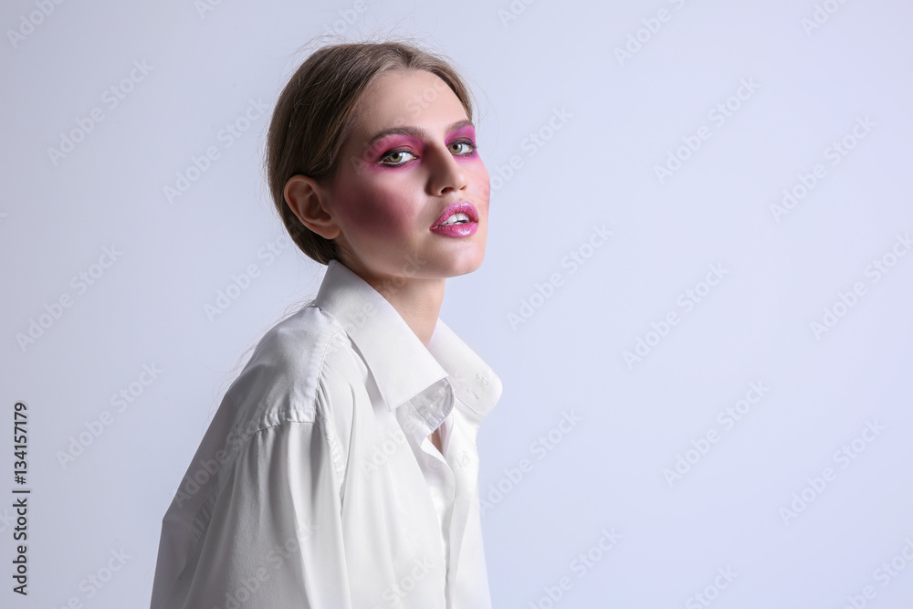 Young model with bright makeup on light background Young model with bright makeup on light background