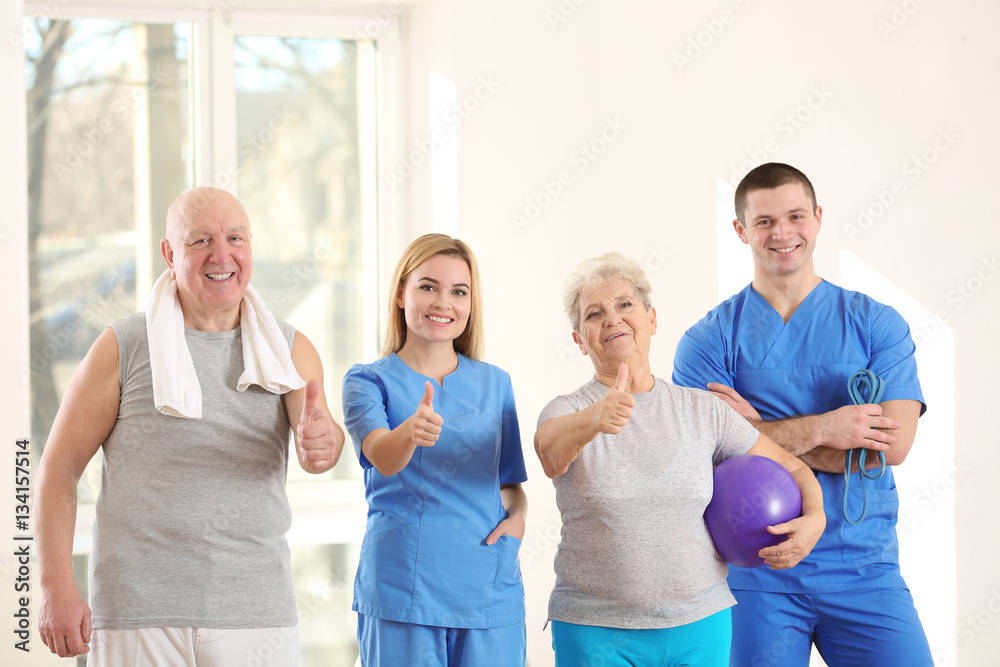 Physiotherapists with elderly patients in clinic Physiotherapists with elderly patients in clinic