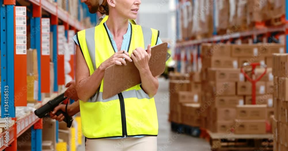 Male and female warehouse worker inspecting stock Male and female warehouse worker inspecting stock