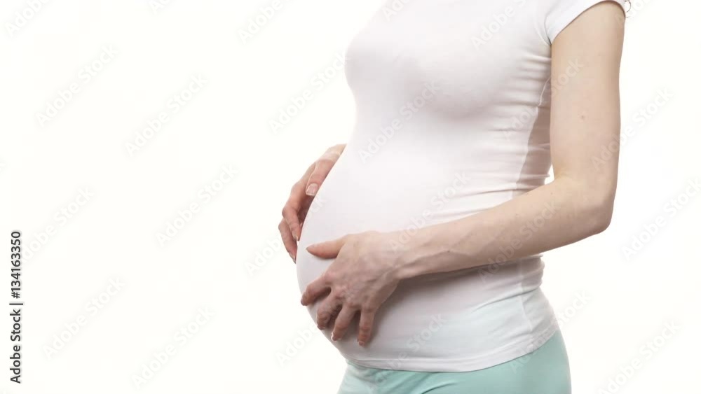 Pregnant woman wearing bright tshirt touching caressing her big belly