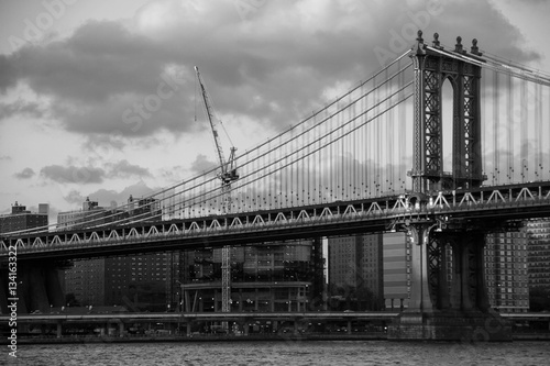 Manhattan bridge over the river and the city in black and white style, New York © Spinel