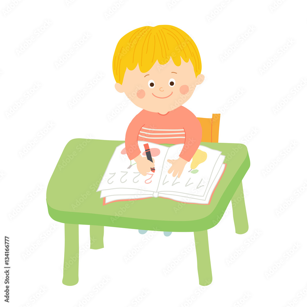 Cute school boy writing at desk in classroom Cute school boy writing at desk in classroom