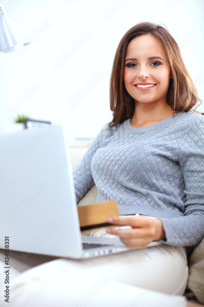 Beautiful smiling woman with laptop and a credit card Beautiful smiling woman with laptop and a credit card