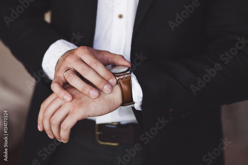 Man in black suit wear new watches. Luxury style