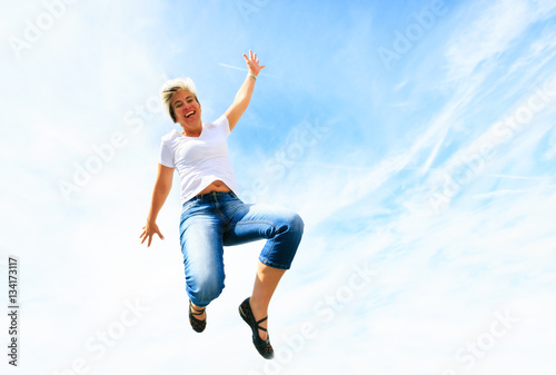 Woman In Her 50s Jumping High Into The Sky