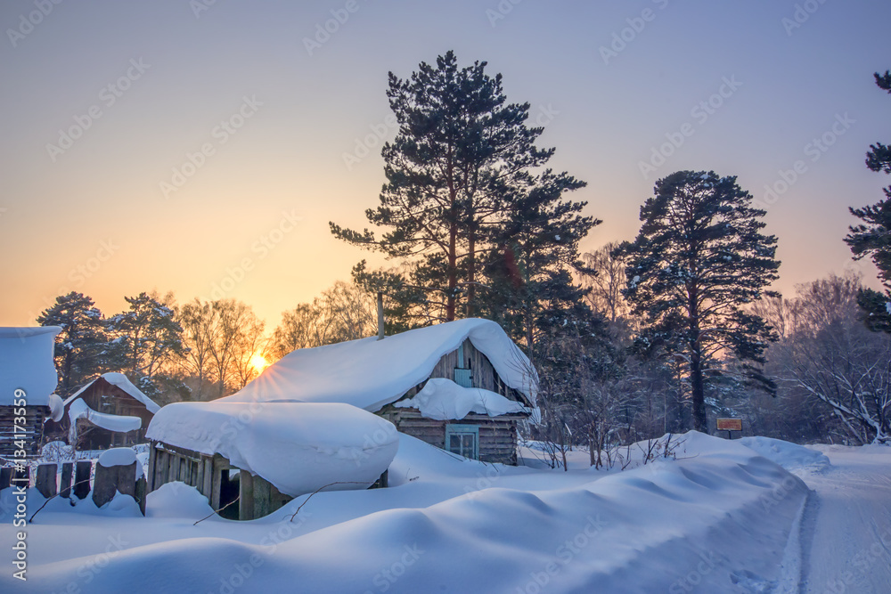 winter landscape with sunset and abandoned cabin under snow