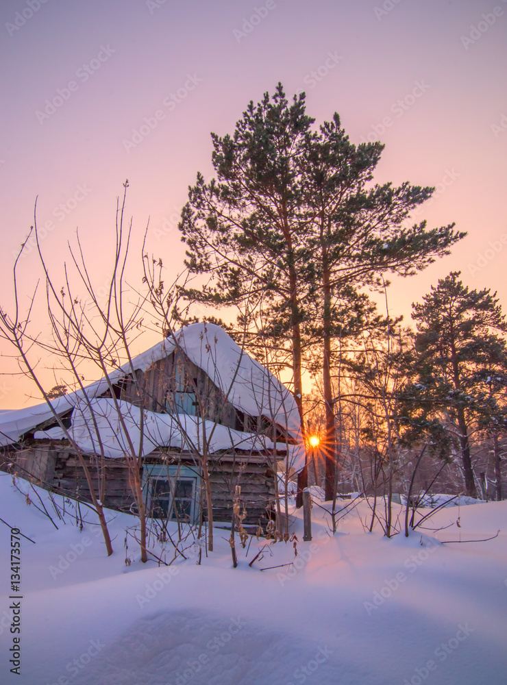 winter vertical background with sunset and abandoned cabin under
