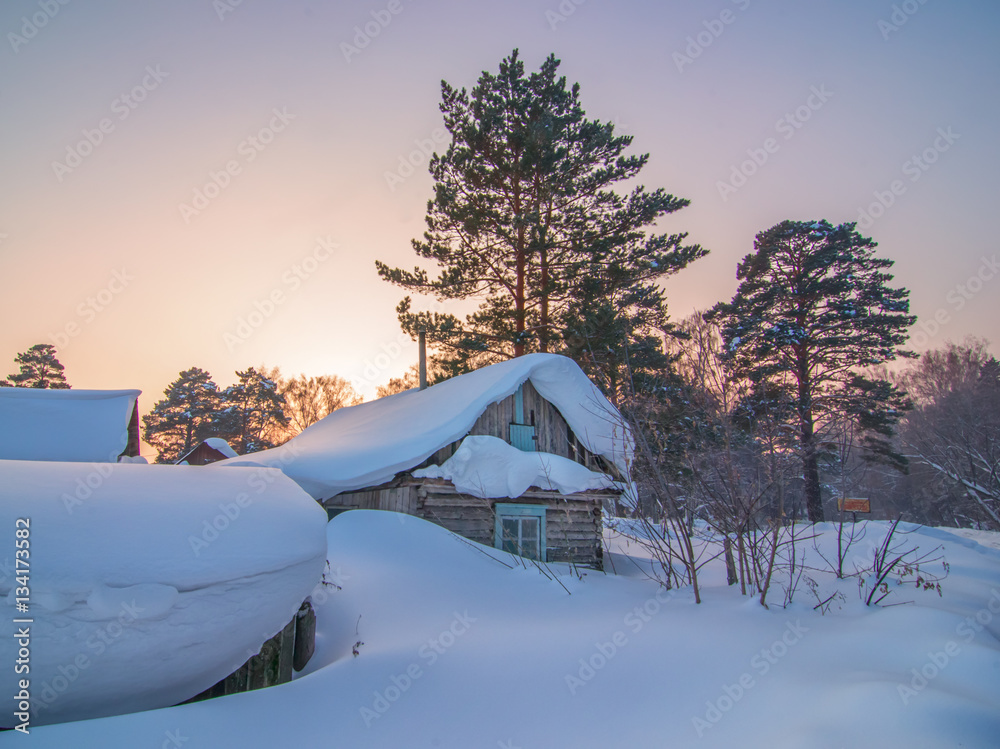 abandoned cabin covered by snow in frozen winter forest under be